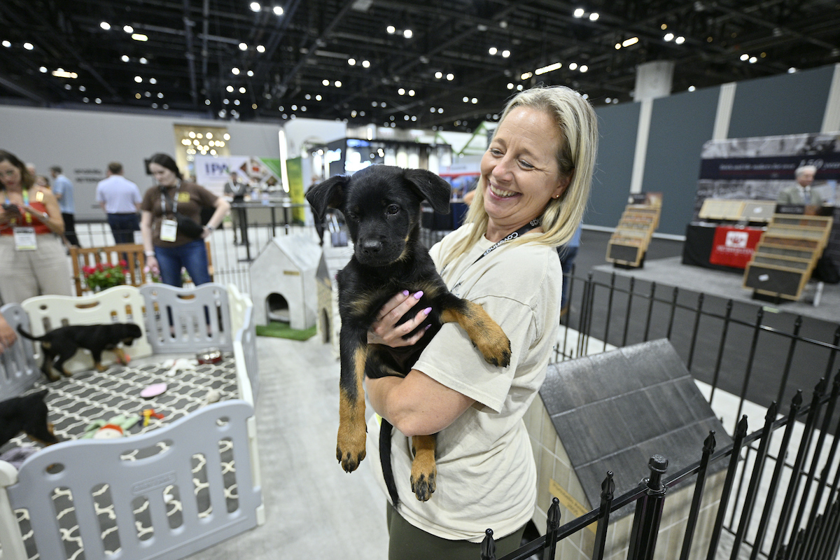 Coverings attendee holding a puppy at the event